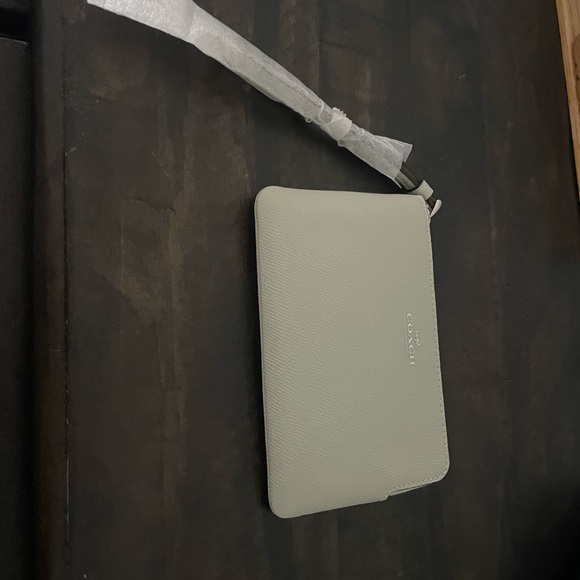 Light grey coach wristlet, with a silvery, gold coach written on it. - Picture 3 of 3